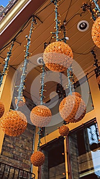 Vertical frame Orange light balls hanging at the entrance of a building with red brick wall