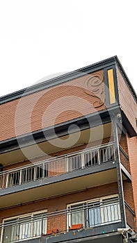 Vertical frame Residential building with flat roof balconies and red brick exterior wall