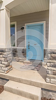 Vertical frame Stape and arched entrance at the porch of home with pastel blue front door