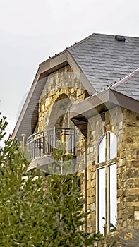 Vertical frame Stone home with half circle balcony and quarter round with extended leg window