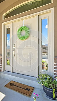 Vertical Front door with wreath transom window and sideligts at the facade of a home photo