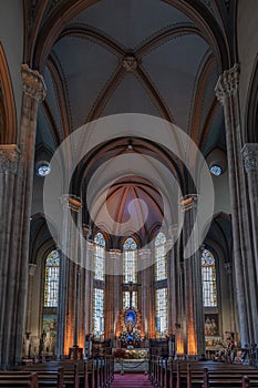 Vertical Glimpse of Saint Antoine Church: Crucifix, Stained Glass, and Domes