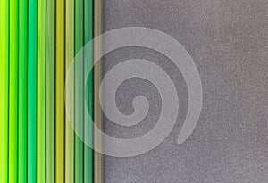 Green colored pencils on dark background top view