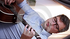 Vertical guitar playing inspired musician home man