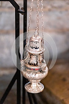 Vertical of a hanging silver incense burner.