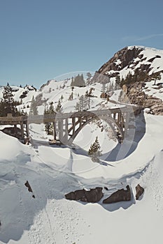 Vertical high angle shot of a bridge in the snowy Donner Summit Mountain pass in California
