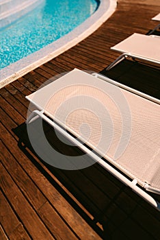 Vertical high-angle shot of folding chairs before a swimming pool