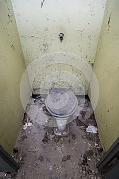 Vertical high-angle shot of an old destroyed and filthy toilet.