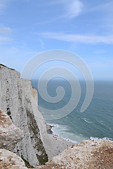 Vertical high angle shot of rocky cliffs near the sea in Dove, England