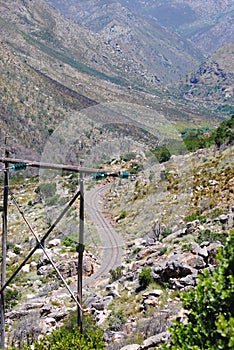 Vertical high angle shot of a winding road with rails in a mountainous area