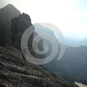 Vertical of a hiker beside Doigt de la Fausse Breche in the French Pyrenees under a morning haze photo