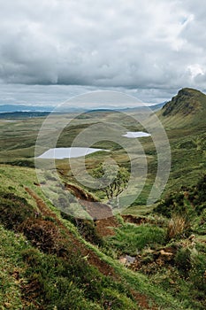 Vertical of hills and lake on Isle of Skie island in Scotland captured under a grey cloudy sky photo