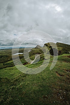 Vertical of hills and a trail on Isle of Skie island in Scotland captured under a grey cloudy sky