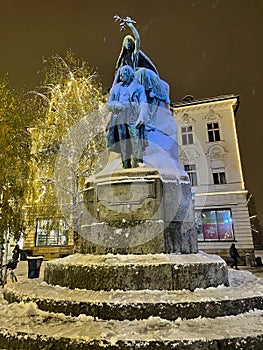 VERTICAL: Historic bronze statue of Preseren and his muse is covered in snow.