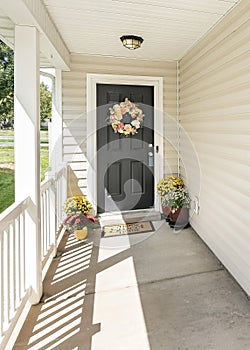 Vertical Home front door exterior with colorful potted flowers and wreath