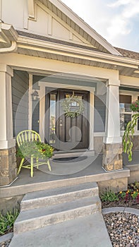 Vertical Home with landscaped yard stairs porch and front door with sidelight and wreath