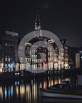 Vertical of houses on Damrak street in Amsterdam, Netherlands at night