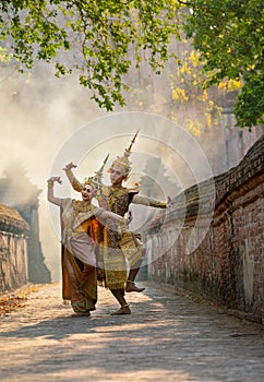 Vertical image of Asian man and woman wear Thai traditional dress and dance with beautifuul cultural style on the way with ancient