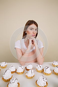 Vertical image of calm woman by the table with cakes