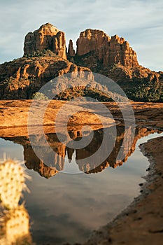 Vertical image of cathedral rock seen from secret slickrock in Sedona Arizona with reflection of geological sandstone rock