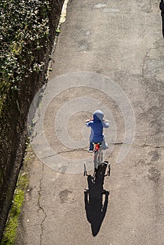 Vertical image child cycling on road