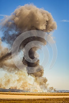 Vertical image of column of smoke from ground up with tornado visible from munitions explosion photo