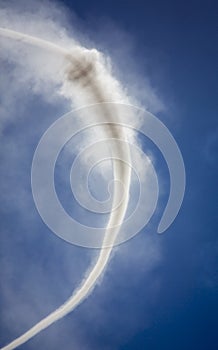 Vertical image of Column of smoke with tornado against blue sky from munitions explosion photo