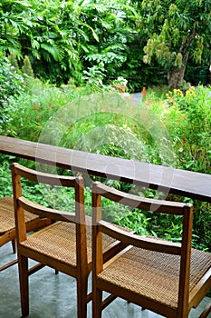 Vertical image of empty wooden chairs and table in a garden