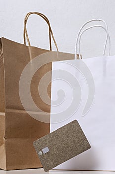 Vertical image f whote and brown craft shopping bags and golden gredit card photo