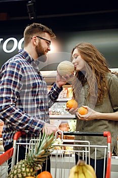 Vertical image of man giving smell melon to his woman