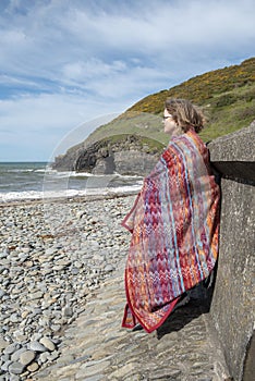 Vertical image of mature woman in fifties wrapped in a red blanket