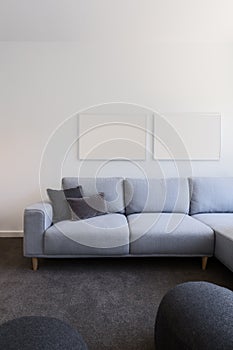 Vertical image of pastel blue sofa with blank artwork above