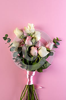 Vertical image of pink and white rose flowers and copy space on pink background