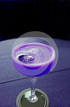 Vertical image of pop art style vivid purple colored cocktail isolated on the table