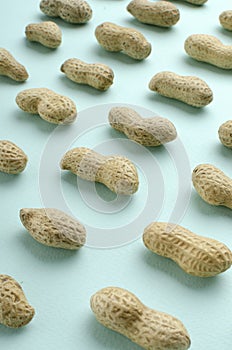 Vertical image.Raws of peanuts on the blue background