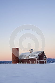 Vertical image red barn with field snowy in winter