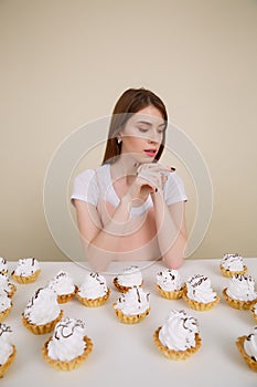 Vertical image of sensual woman by the table with cakes