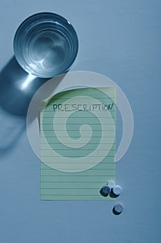 Vertical image.Sheet of paper, pills, glass of water.Night time.Empty space for text photo