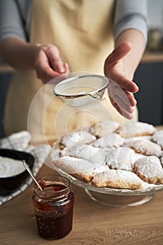 Vertical image of sprinkling and decorating cookies with powdered sugar