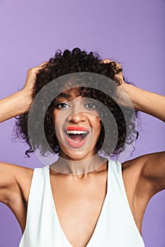 Vertical image of Surprised happy pretty african woman holding head