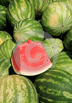 Vertical image of large watermelons, one sliced open to show freshness photo