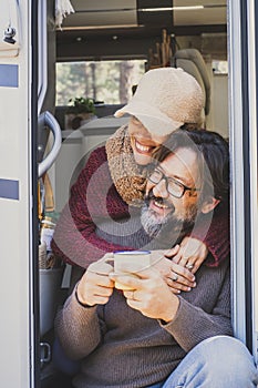 Vertical image of tourists with campe van vehicle. Adult man and woman enjoying nature and travel lifestyle. Van life with modern photo