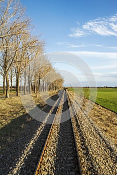 Vertical image of train tracks taken from the caboose speeding through southern Bulgaria