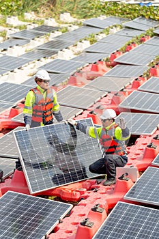 Vertical image of two professional technician workers hold solar cell panels during installation or set up to the system and they