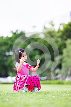 Vertical image. A young girl is stumped alone after losing a soccer match, a child sits on a soccer ball. photo