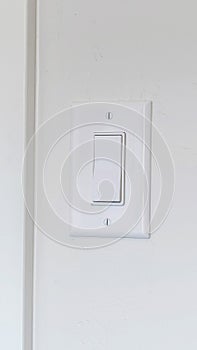 Vertical Indoor electrical light switch of home mounted on white wall background
