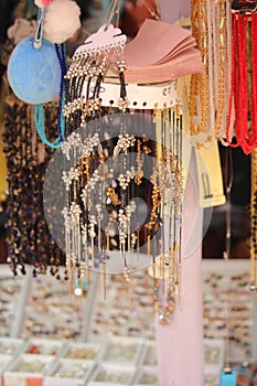 Vertical of jewelry display in a flea market, hung on strings - concept of accessories