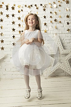 Vertical joyful little girl in an elegant dress