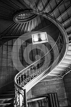 Vertical low angle grayscale shot of a staircase in an ancient building