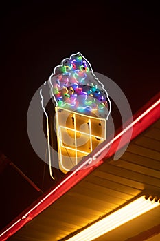 Vertical low angle of an ice-cream cone made with colorful lights on a store building